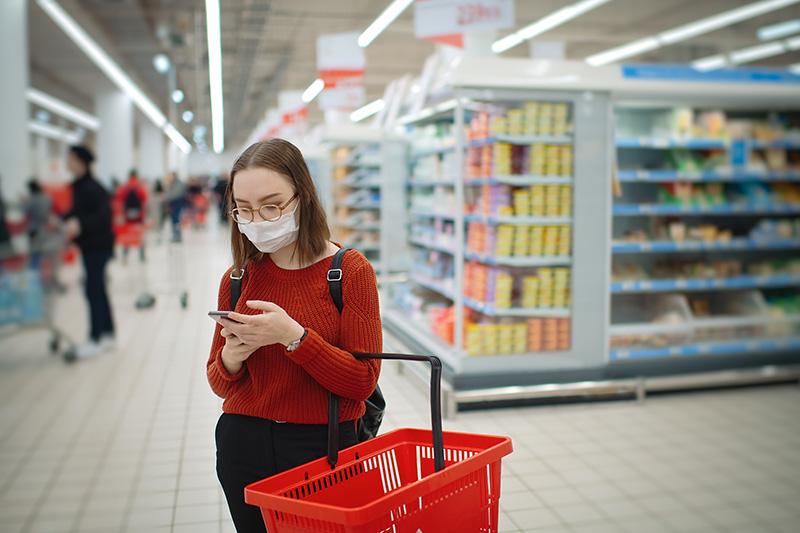 女顾客在购物时阅读Heart-Check认证产品清单