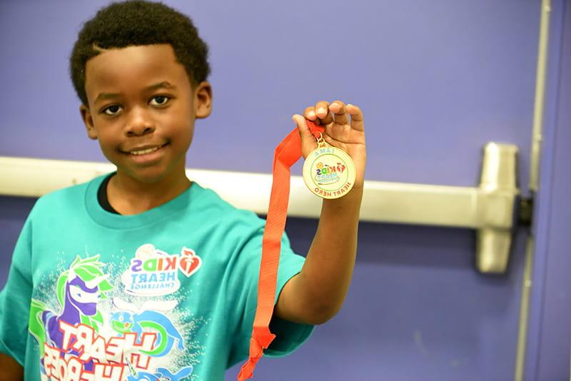 young boy showing off medal