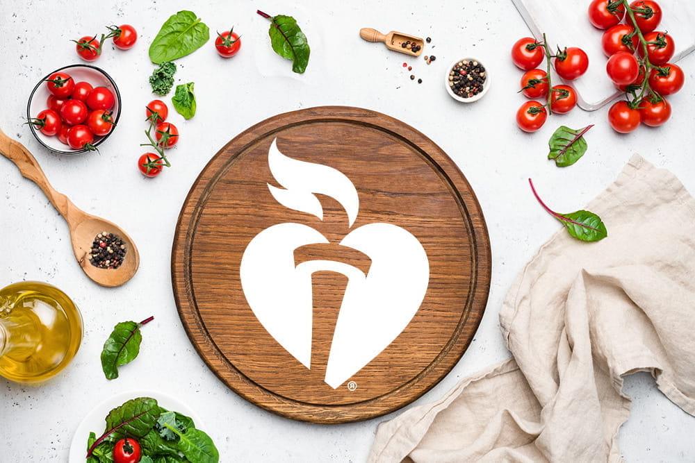 cutting board with aha logo and vegetables